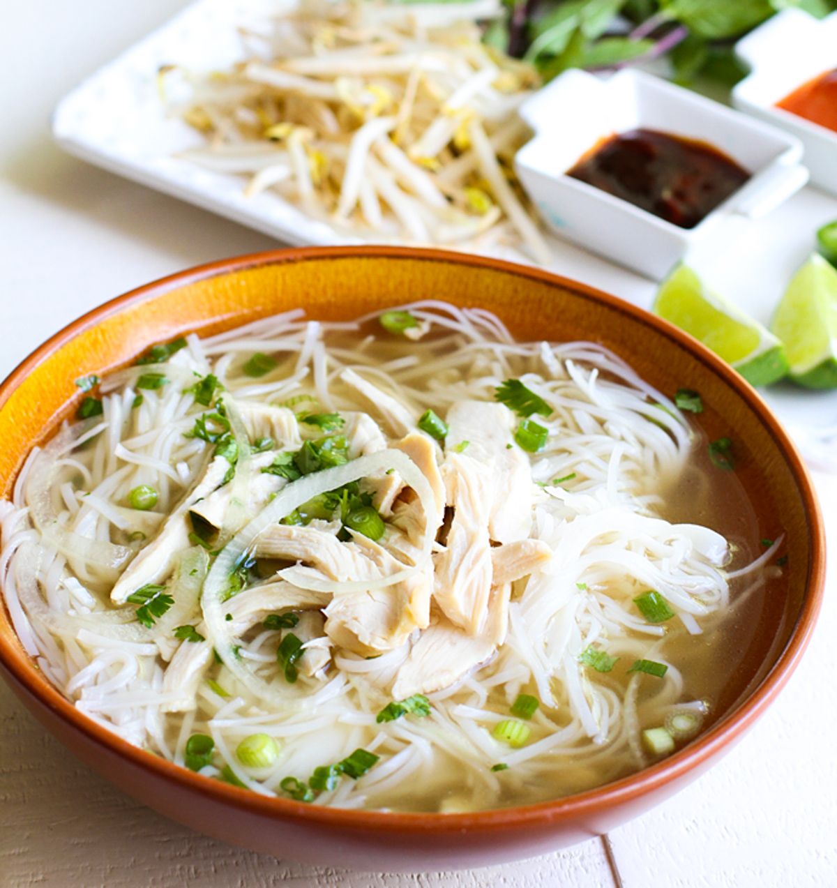 bowl filled with cooked rice noodles and pho ga broth