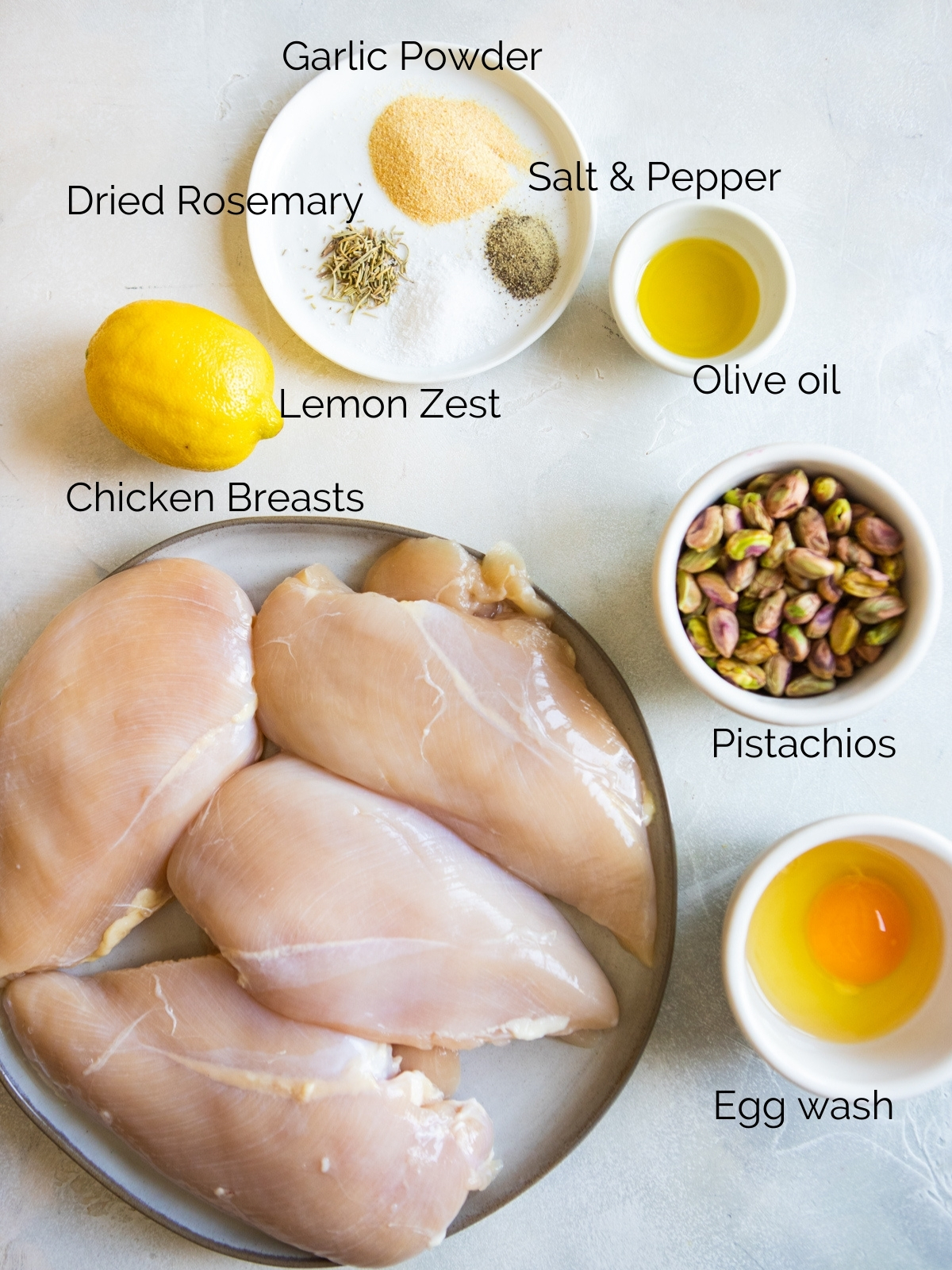 various plates and bowls of ingredients to make pistachio crusted chicken