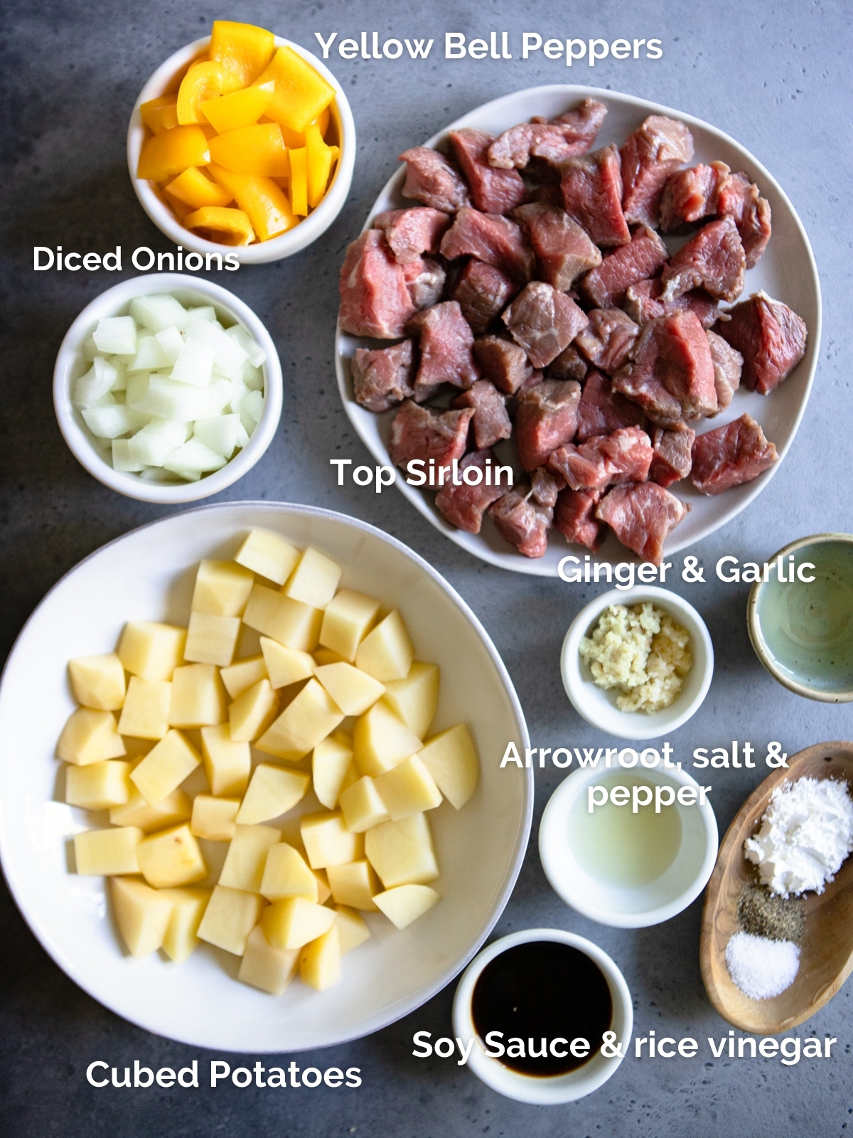 ingredients for a beef and potato dish spread out on a gray background