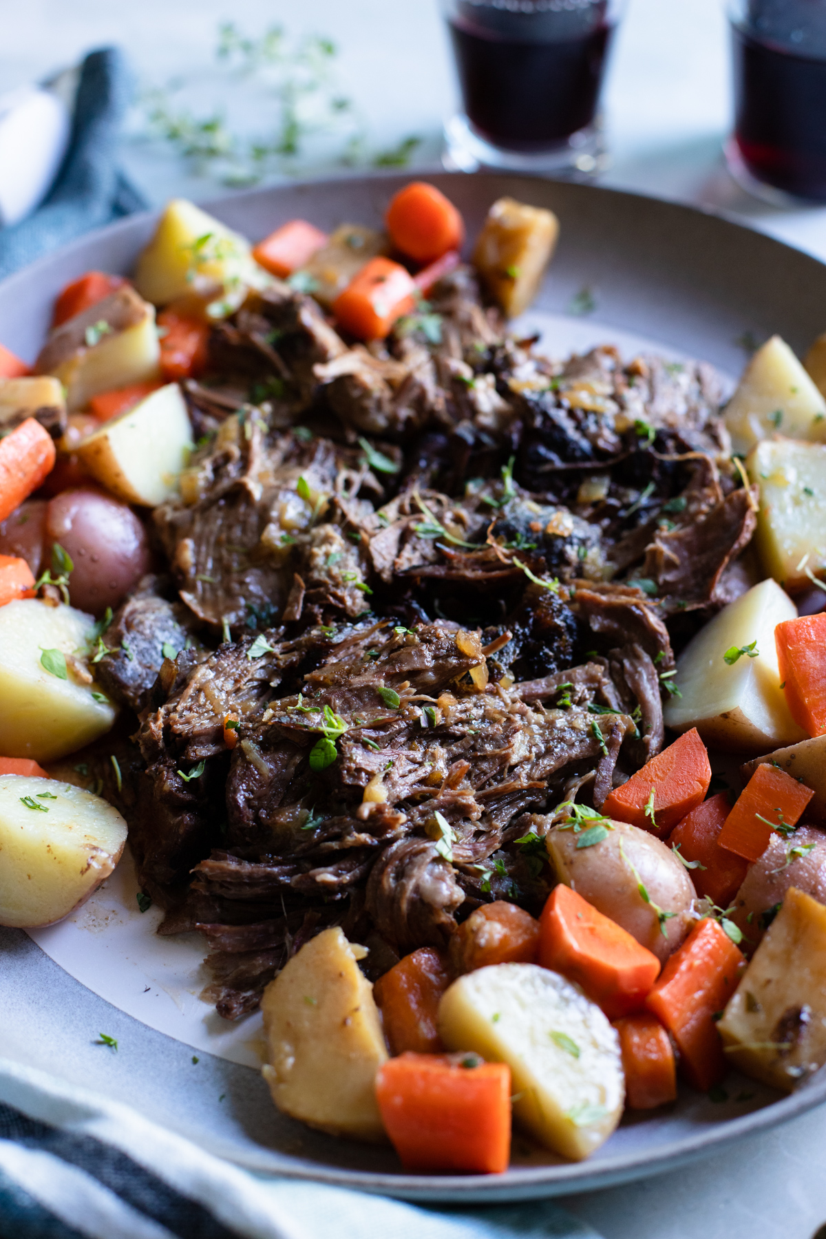beef chuck roast cooked in a slow cooker surrounded by vegetables 