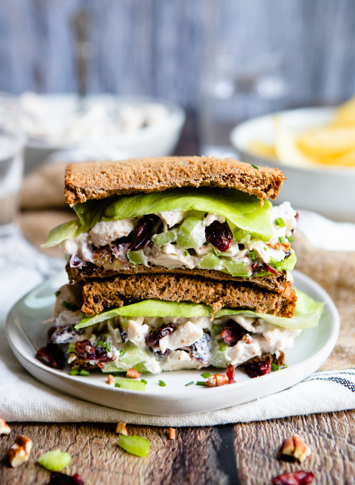 brown bread chicken sandwich stacked on top of a white plate