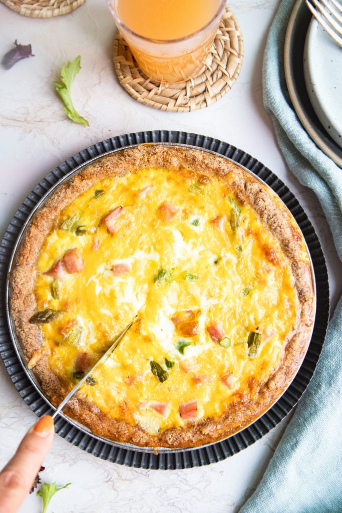 knife being cut into a baked quiche