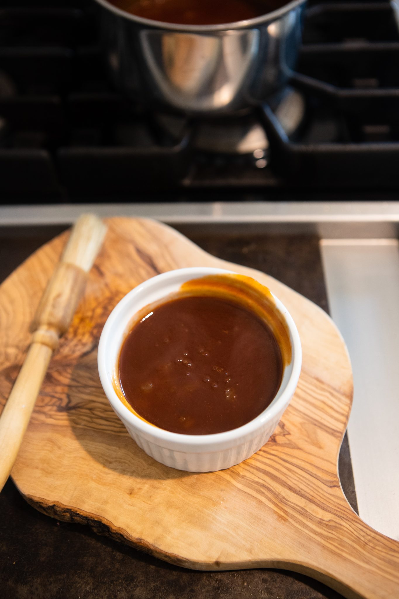 homemade BBQ sauce in a white ramekin on a wood board