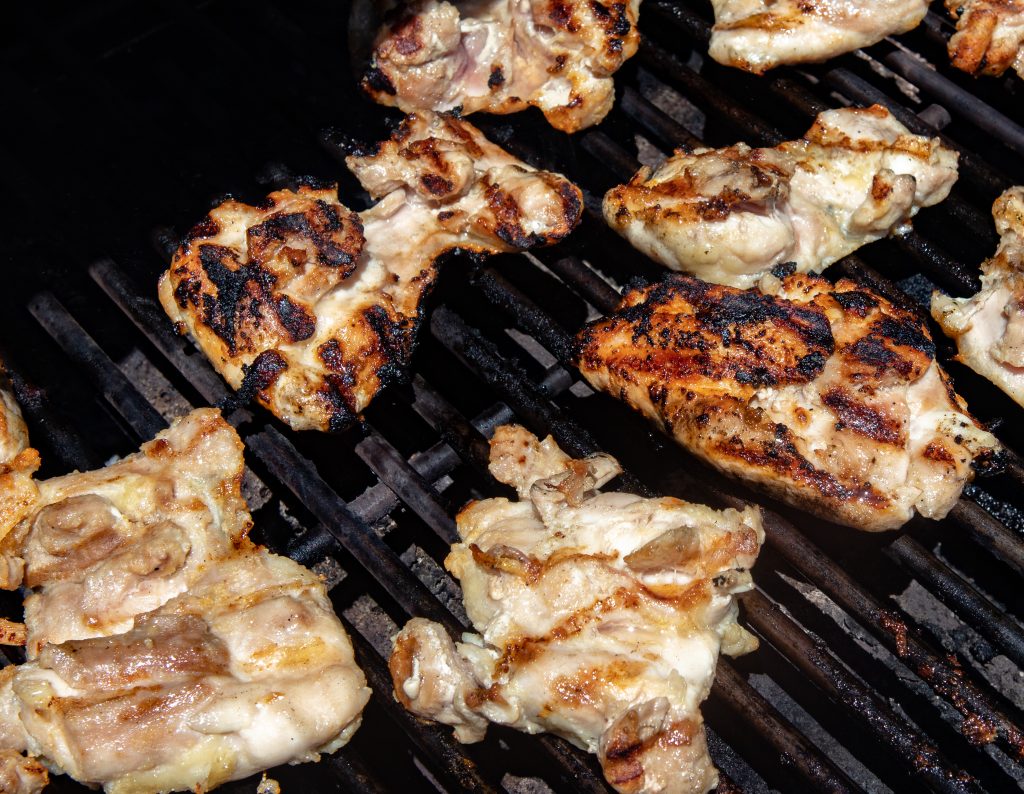 chicken thighs being grilled on a gas grill