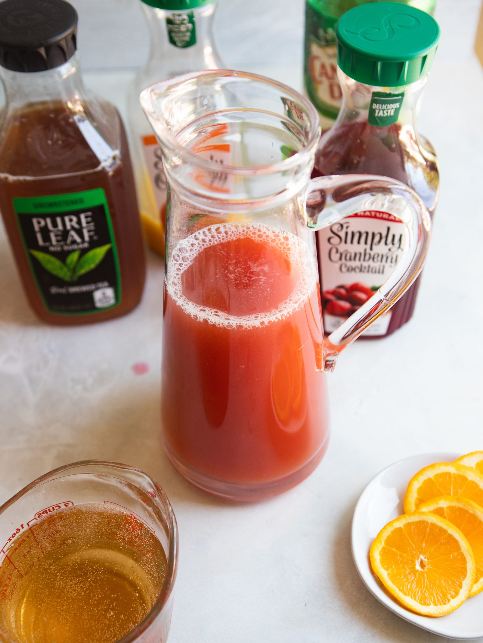 glass pitcher filled with iced tea and cranberry juice