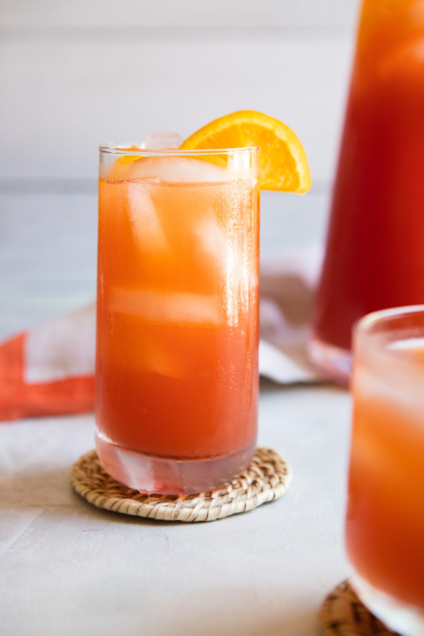 tall glass filled with iced tea and ice cubes garnished with citrus slices