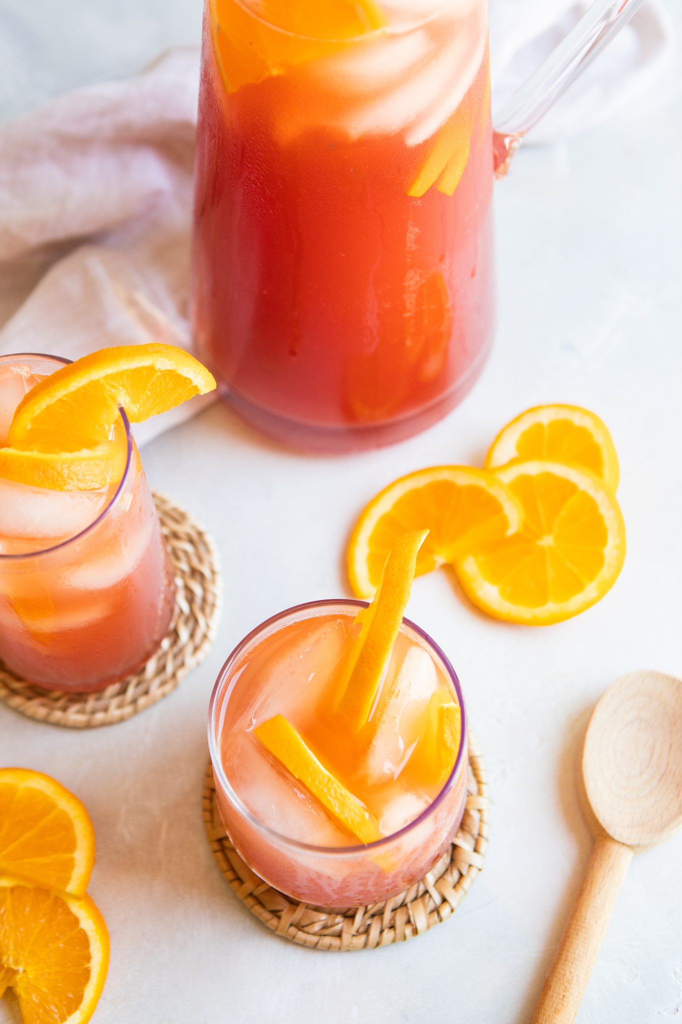 glass pitcher filled with fruit tea garnished with orange slices 