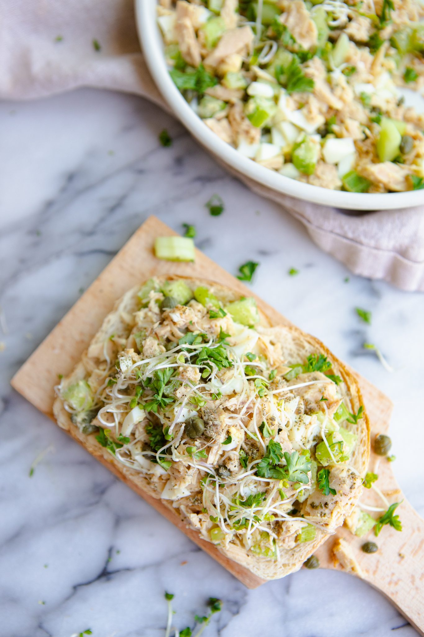 small wooden board with a piece of sourdough toast on top covered in tuna salad made with no mayo