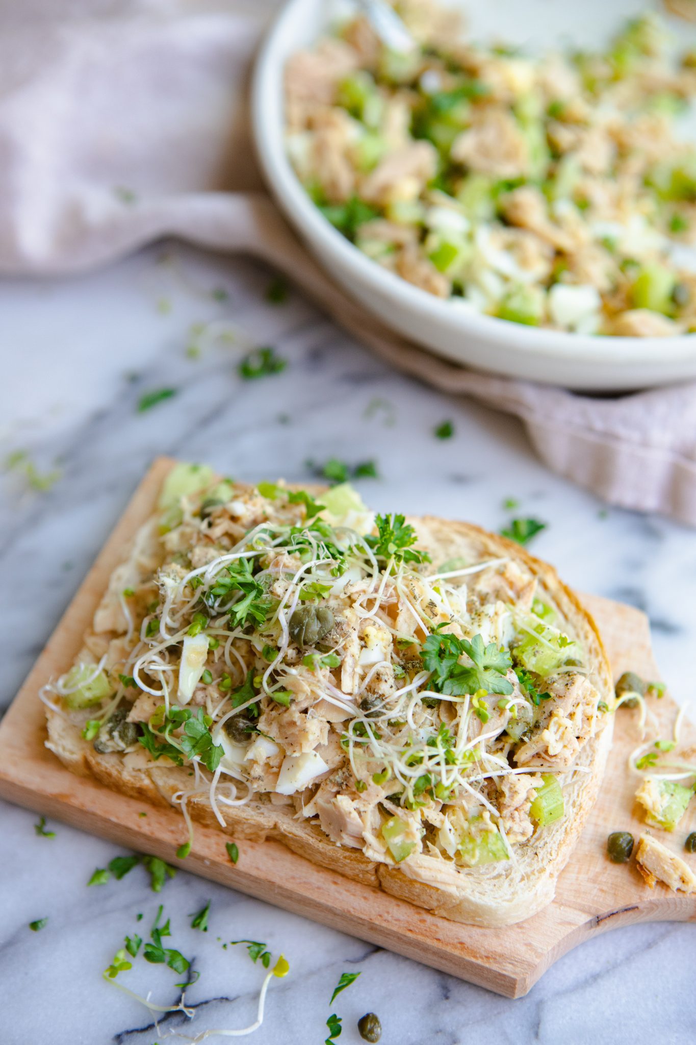 tuna salad no mayo recipe on a piece of sourdough toast on a marble countertop