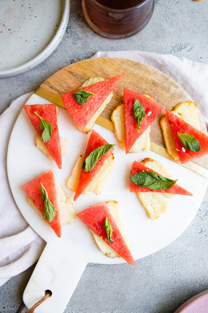 halloumi cheese and watermelon slices on a marble tray garnished with mint