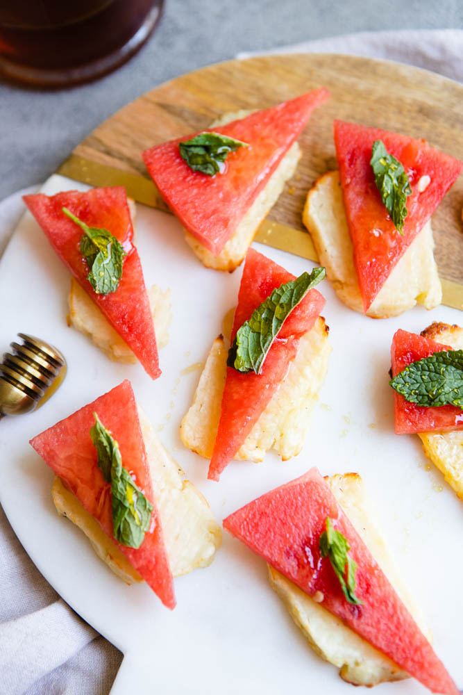 slices of air fryer halloumi topped with watermelon and drizzled with honey