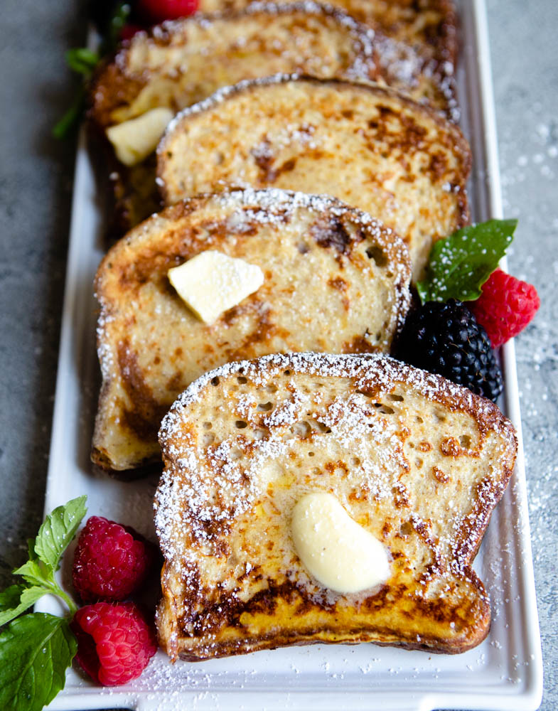 slices of golden brown high protein french toast on a white platter