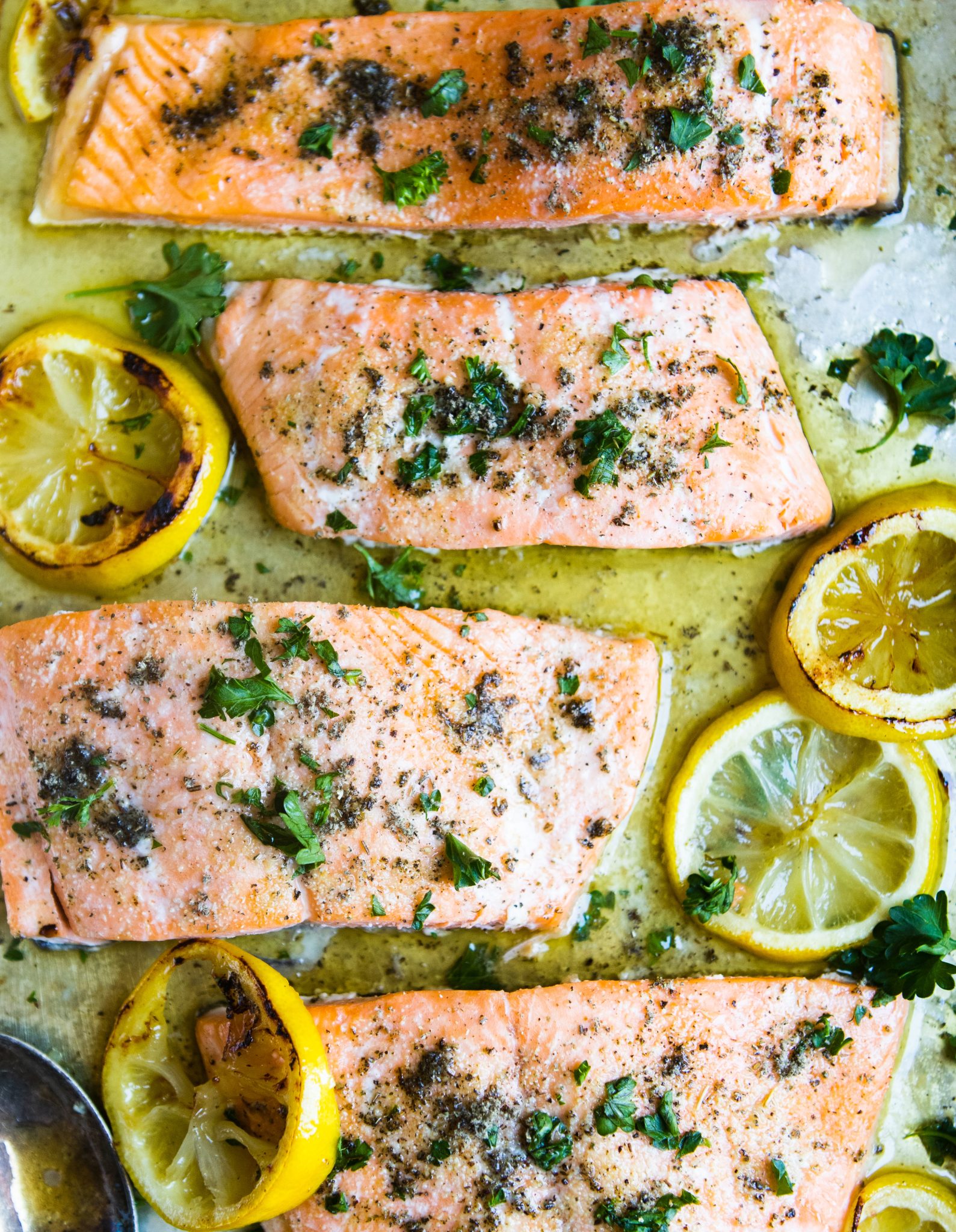 baked salmon drizzled with butter and garlic lemon sauce and sprinkled with fresh parsley