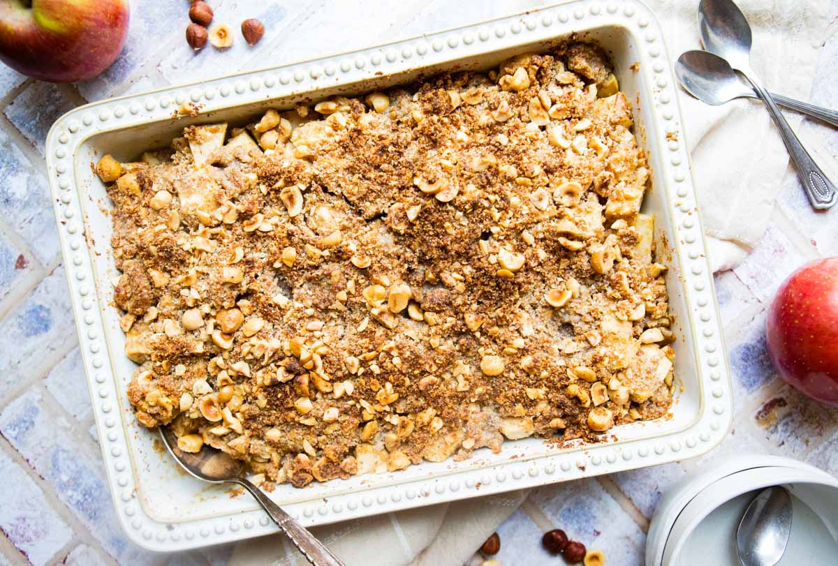 healthy apple crumble fresh out of the oven in a white rectangle baking dish