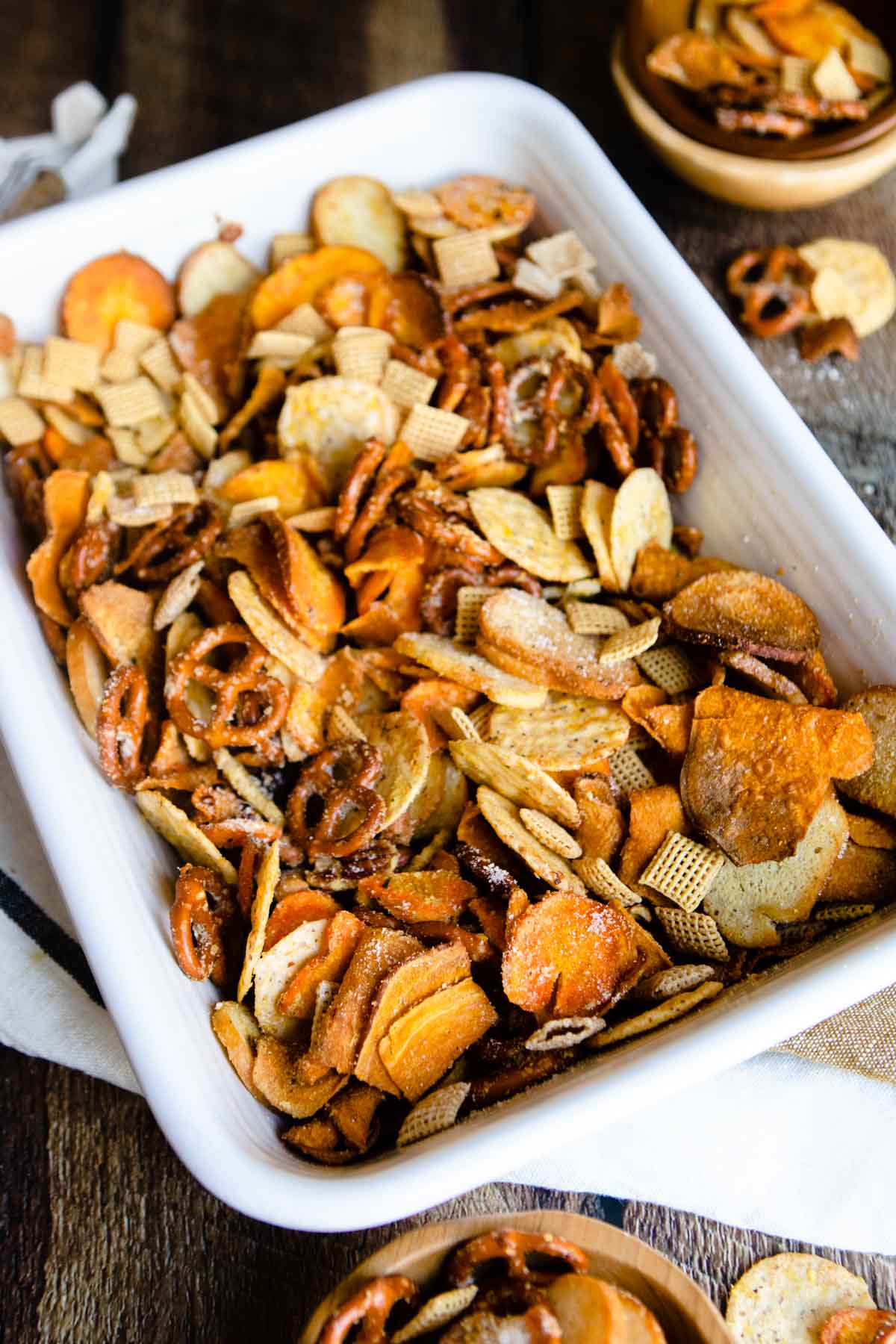 white casserole dish filled with parmesan ranch bold chex mix set on a wood table