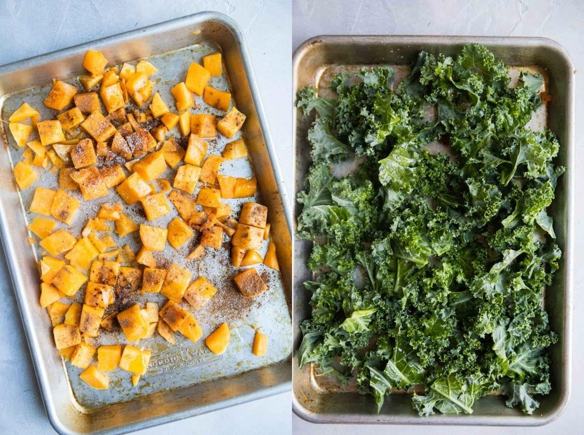 raw butternut squash and raw kale on a rimmed baking sheet ready to be roasted