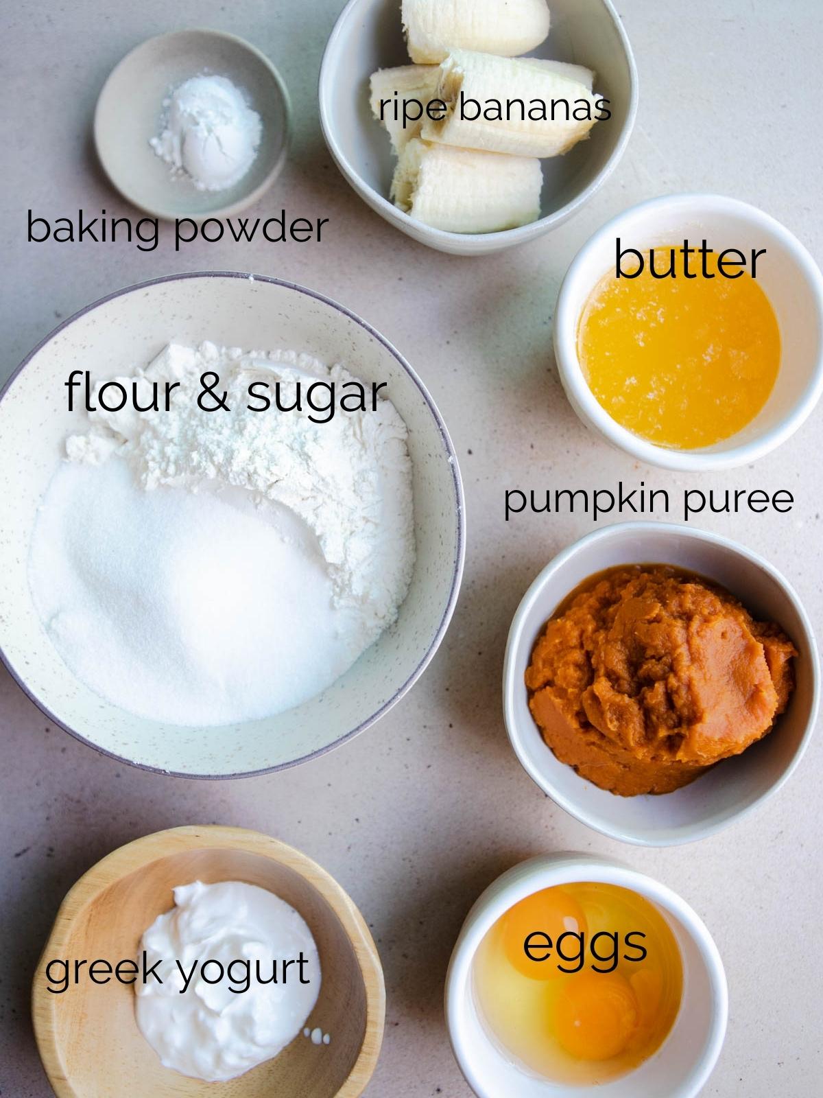 raw ingredients to make pumpkin muffins set out in small white bowls