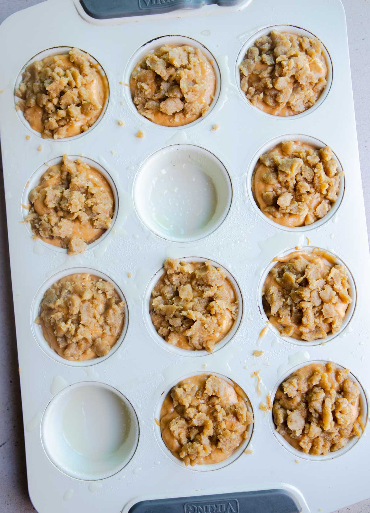 raw pumpkin banana muffins in a muffin tin with streusel topping 