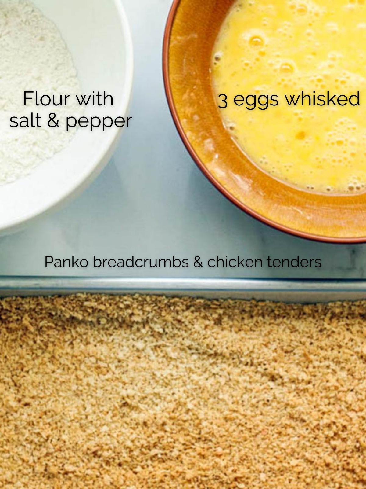 panko breadcrumbs on a baking sheet next to 2 bowls, one filled with whisked eggs and the other filled with flour, salt and pepper