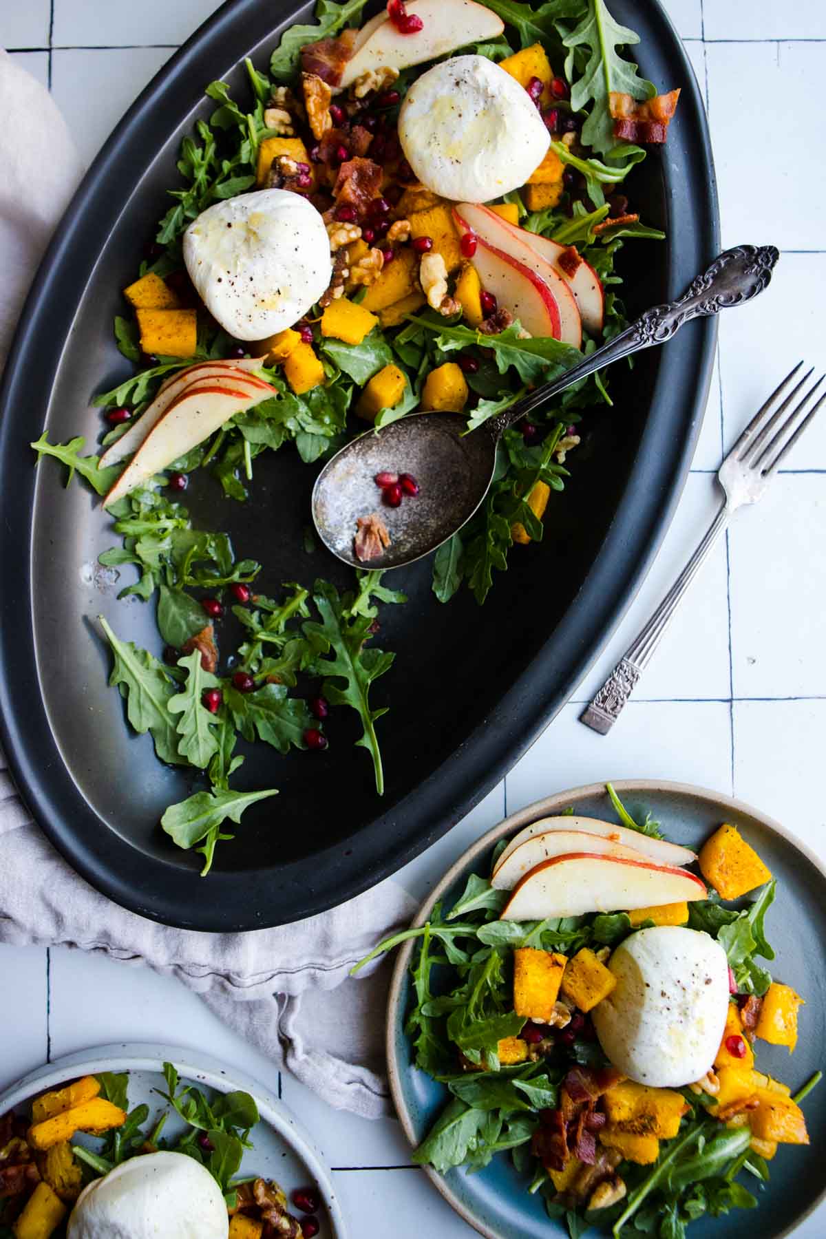 arugula topped with roasted pumpkin, pomegranate seeds, pear slices and burrata cheese 