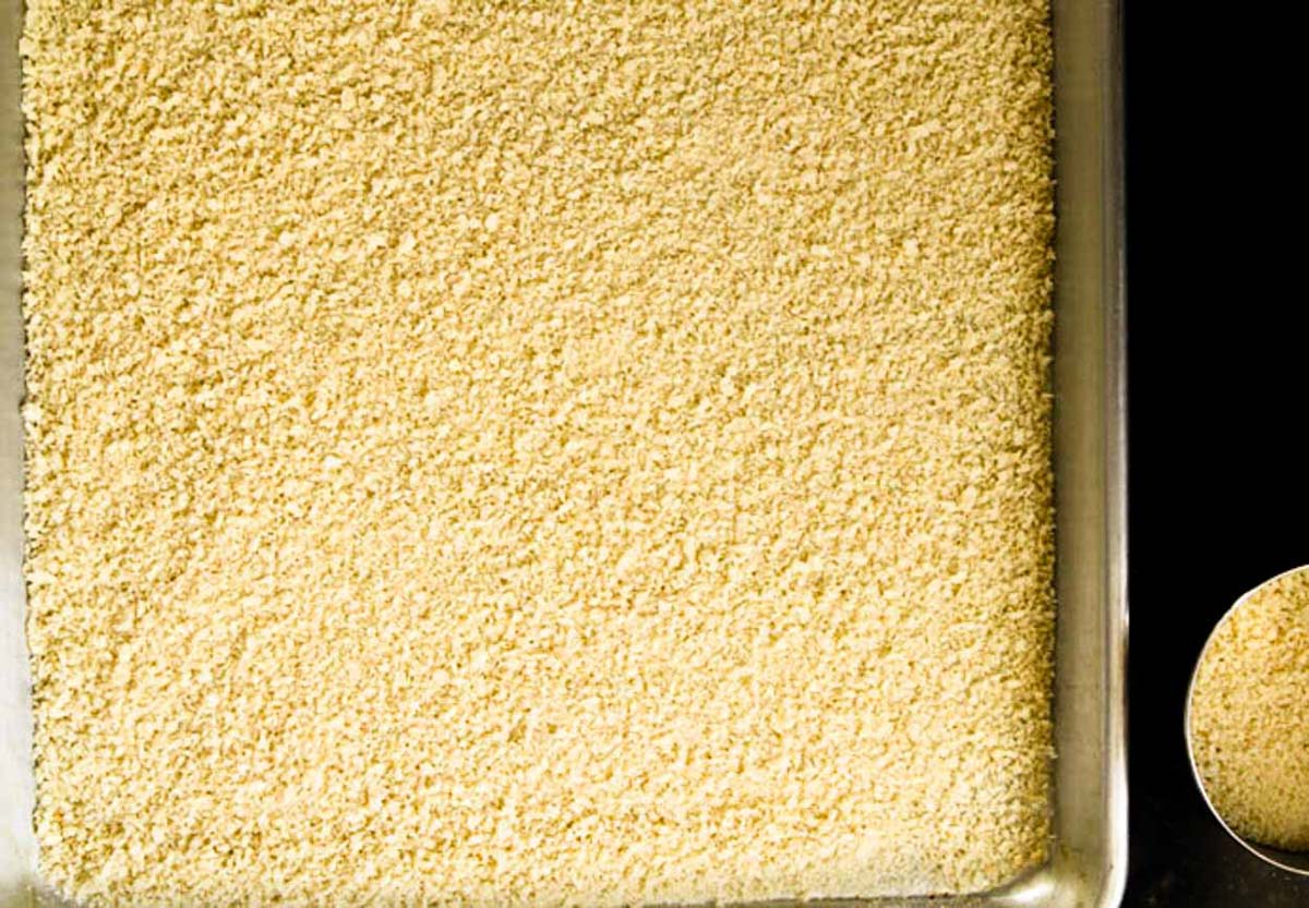 panko breadcrumbs spread out on a rimmed baking sheet to bake in the oven and make crispier 