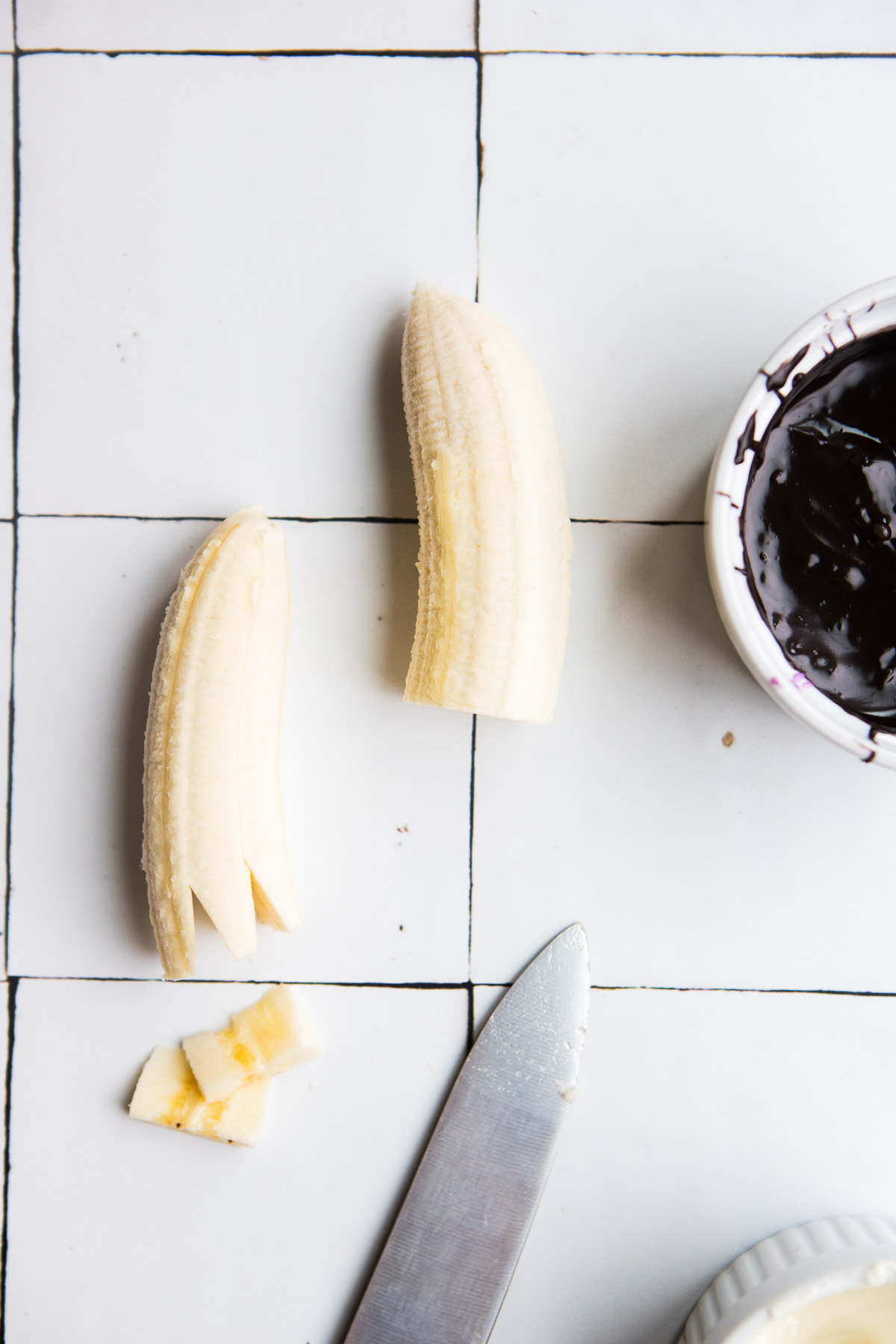 2 halves of a banana with triangles cut out in the bottom to make a zigzag bottom