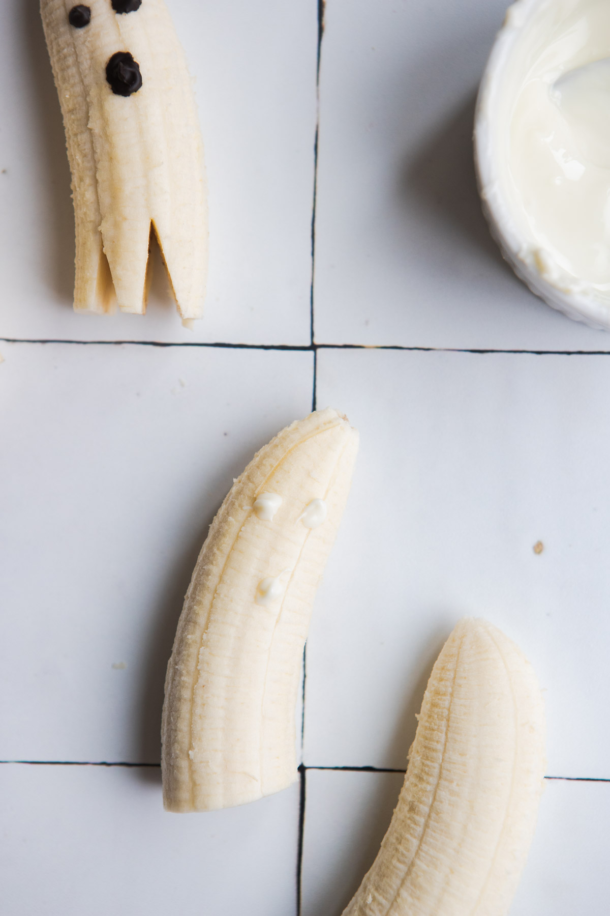 3 white chocolate dots drawn on a banana 