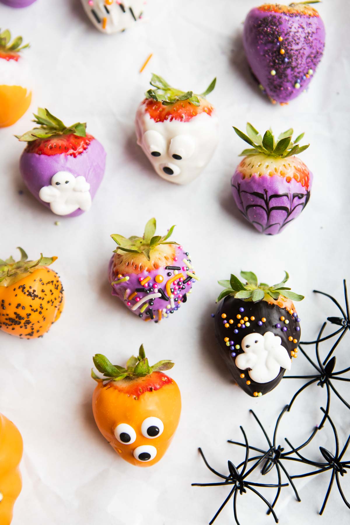 white chocolate covered strawberry meant to look like a ghost next to various decorated chocolate covered strawberries