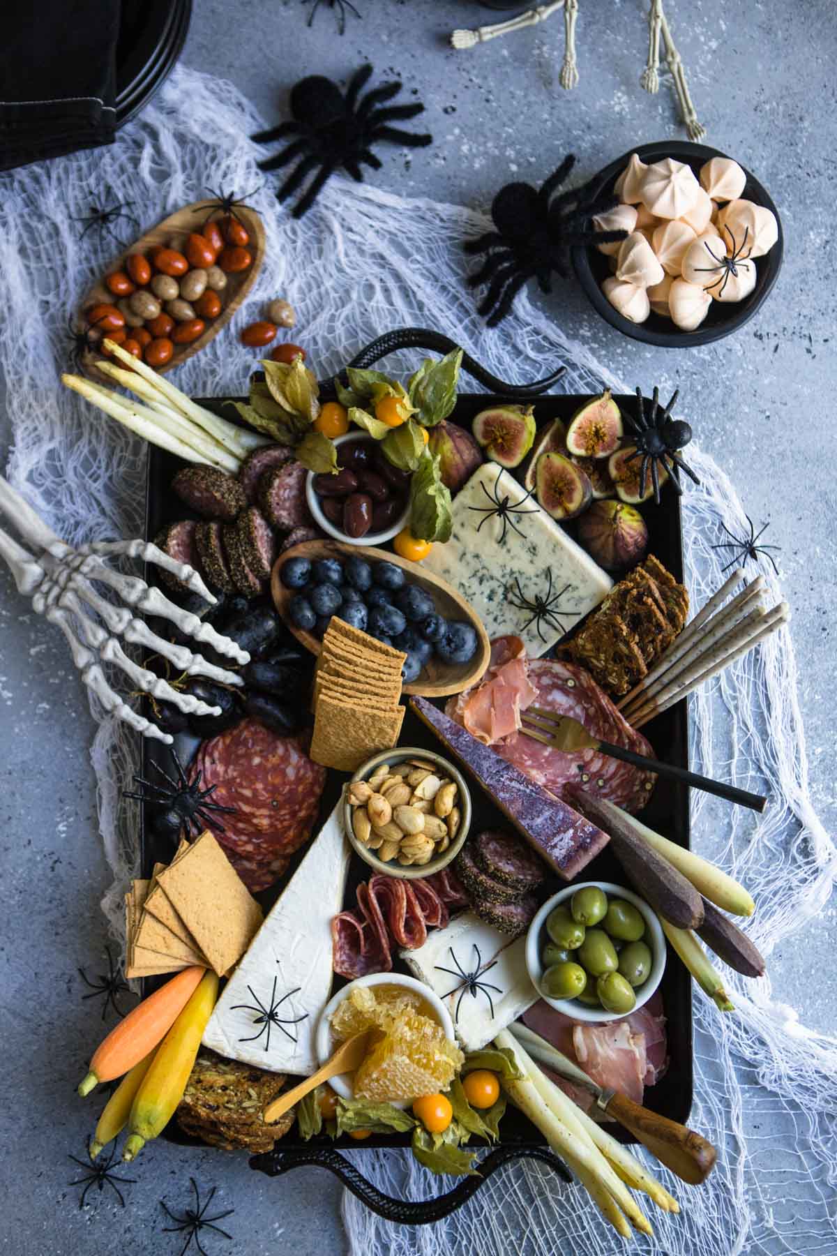gray board with white gauze with a black snake tray topped with cheeses and meats