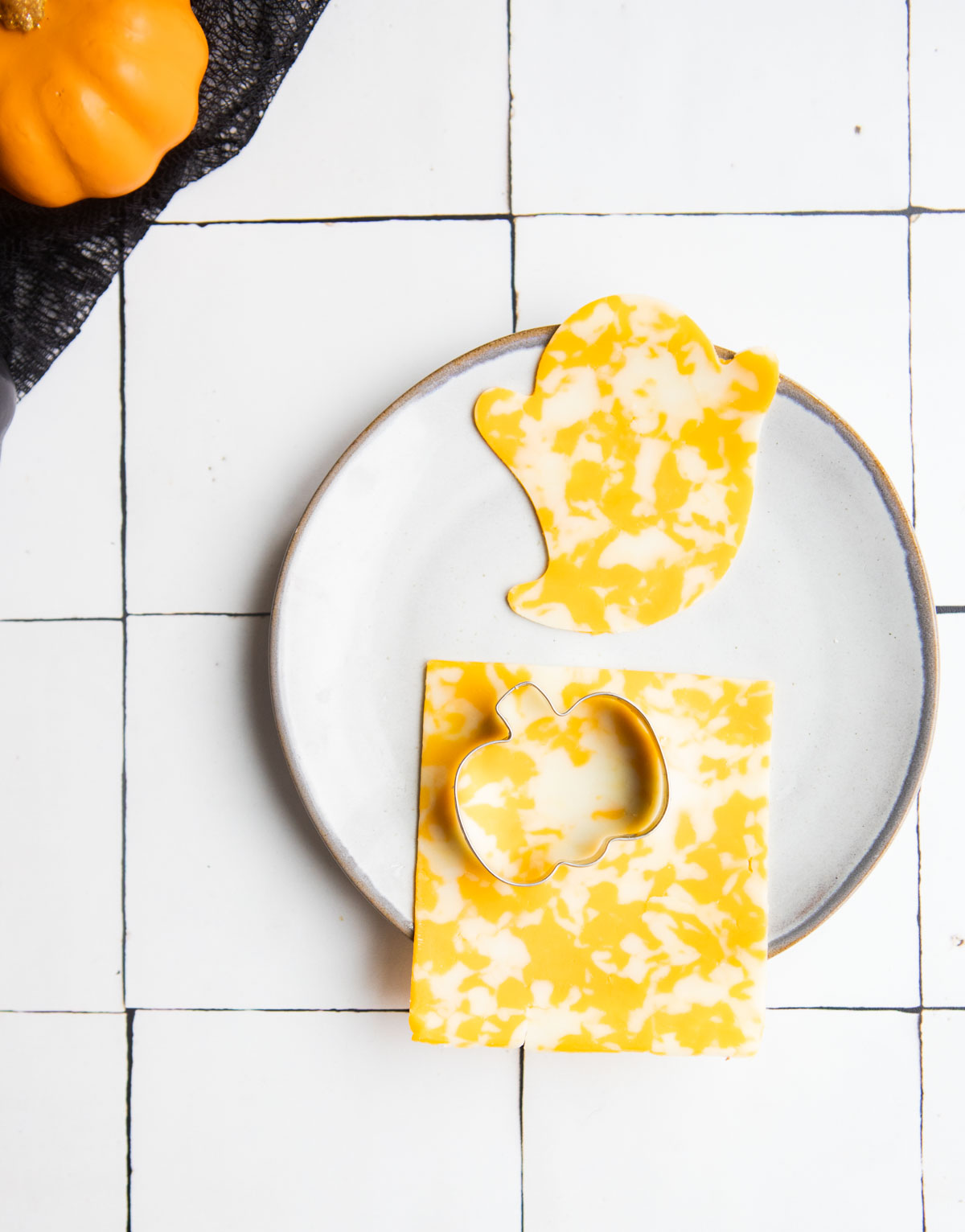 pumpkin cookie cutter cutting out a piece of cheese