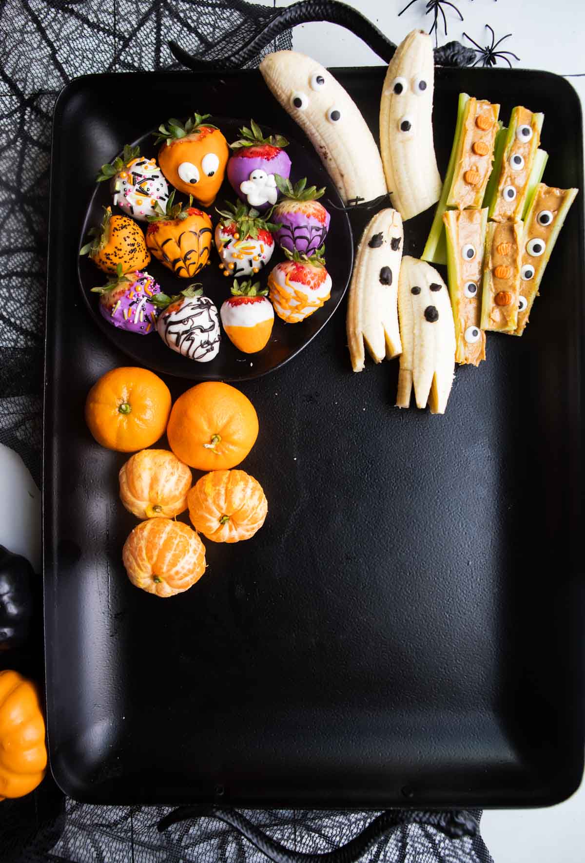 Halloween themed fruit on a black tray