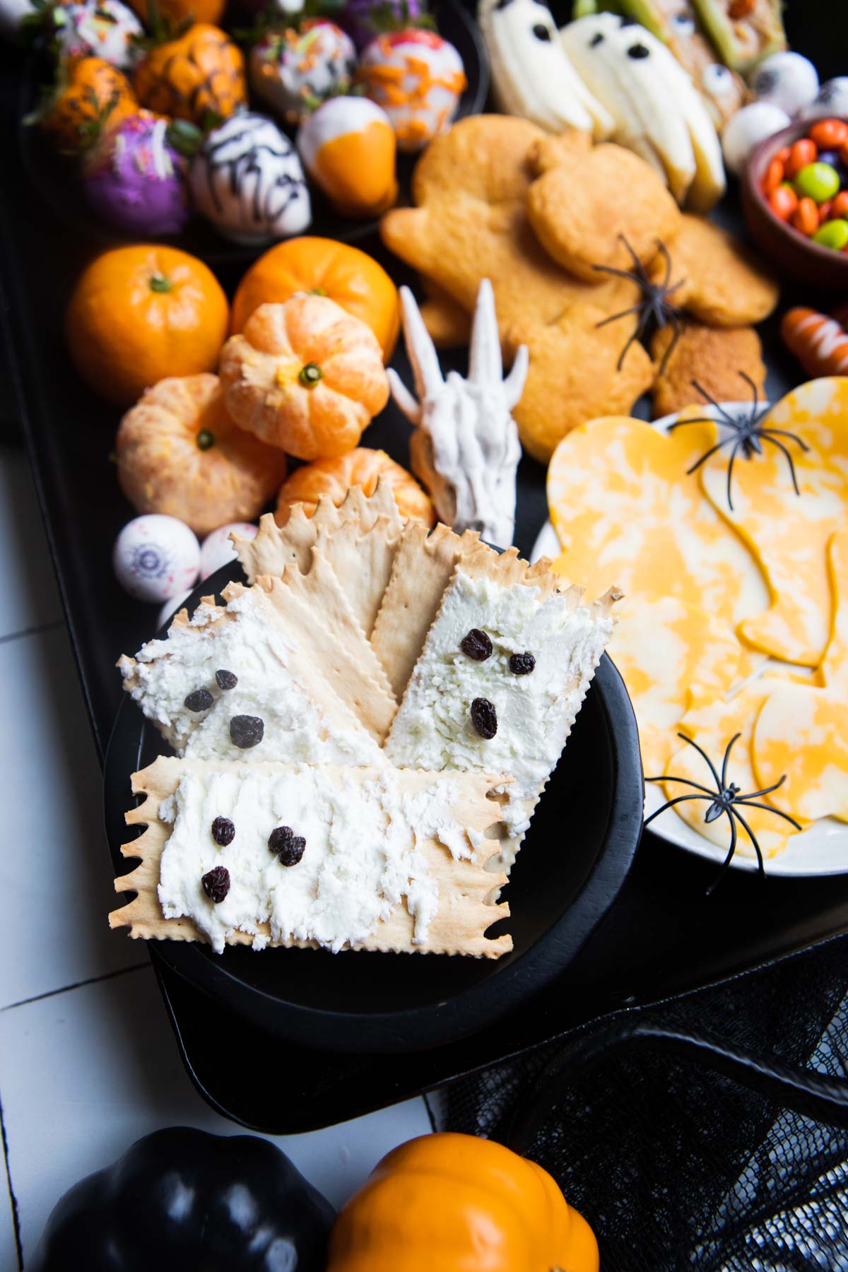 goat cheese spread crackers with currants for eyes and mouth to look like a ghost