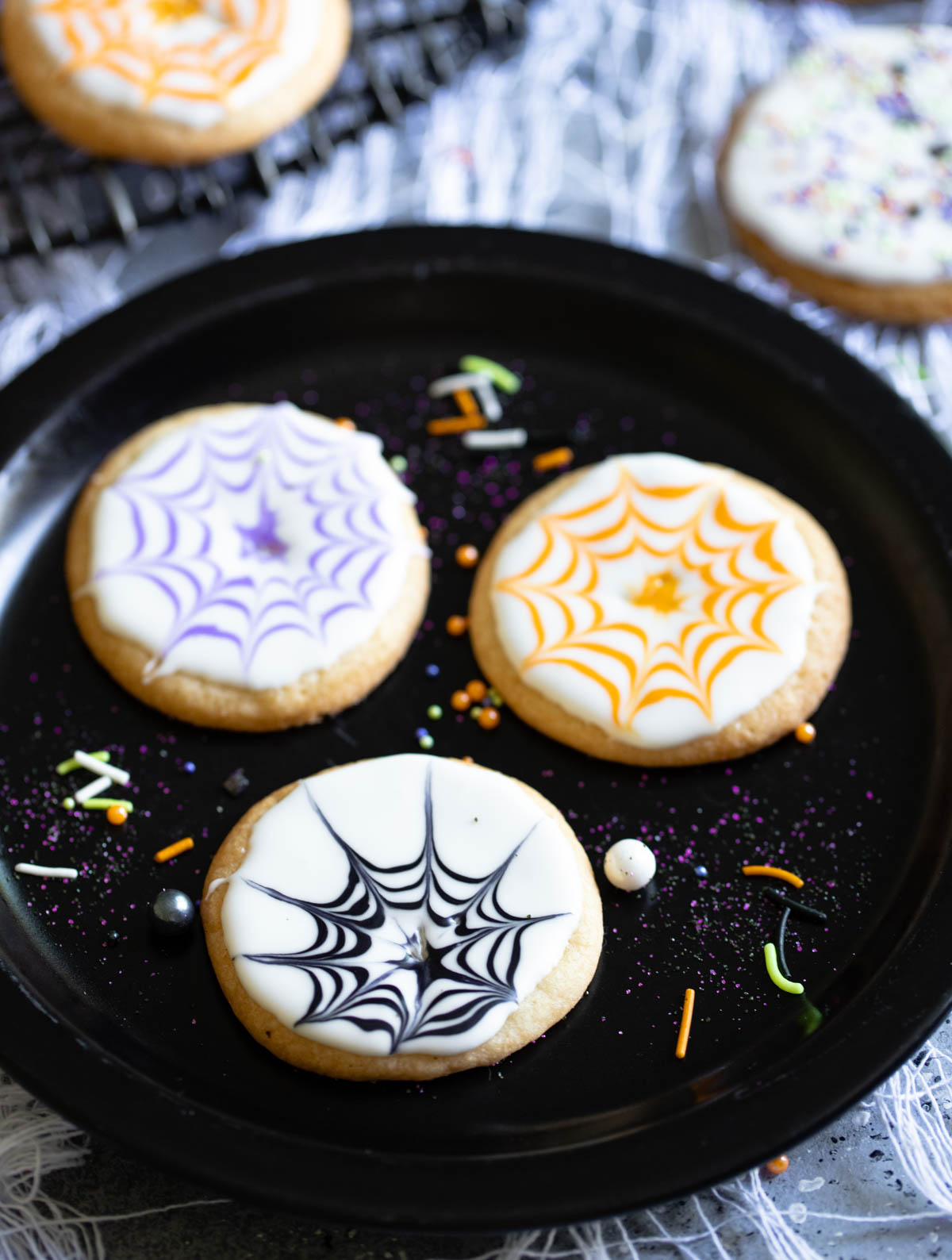 Black plate filled with decorated Halloween cookies 