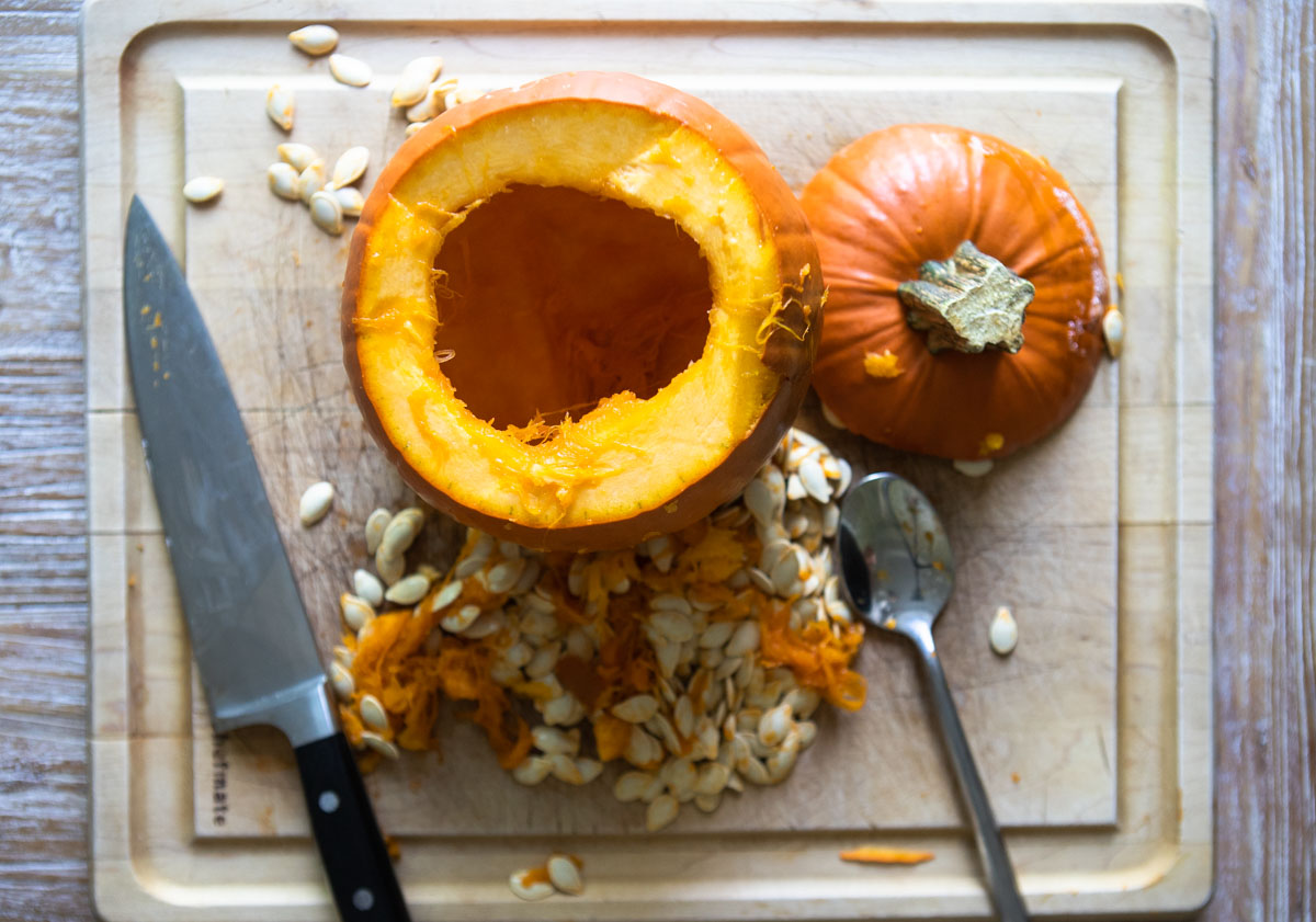 sugar pumpkin with top cut off and seeds scooped out of inside 