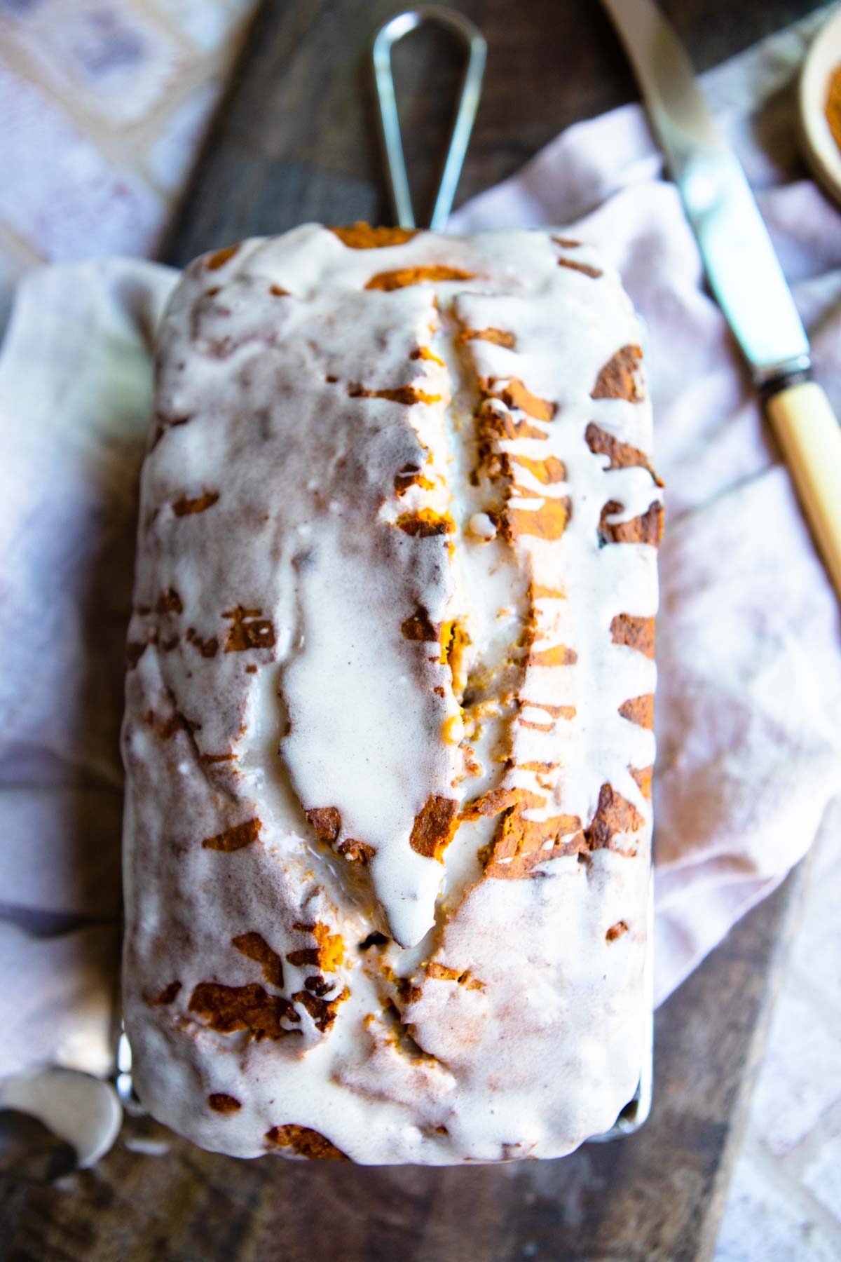 loaf of pumpkin quick bread covered in pumpkin spice glaze 