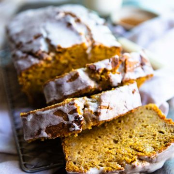 sliced pumpkin banana bread loaf with a powdered sugar glaze