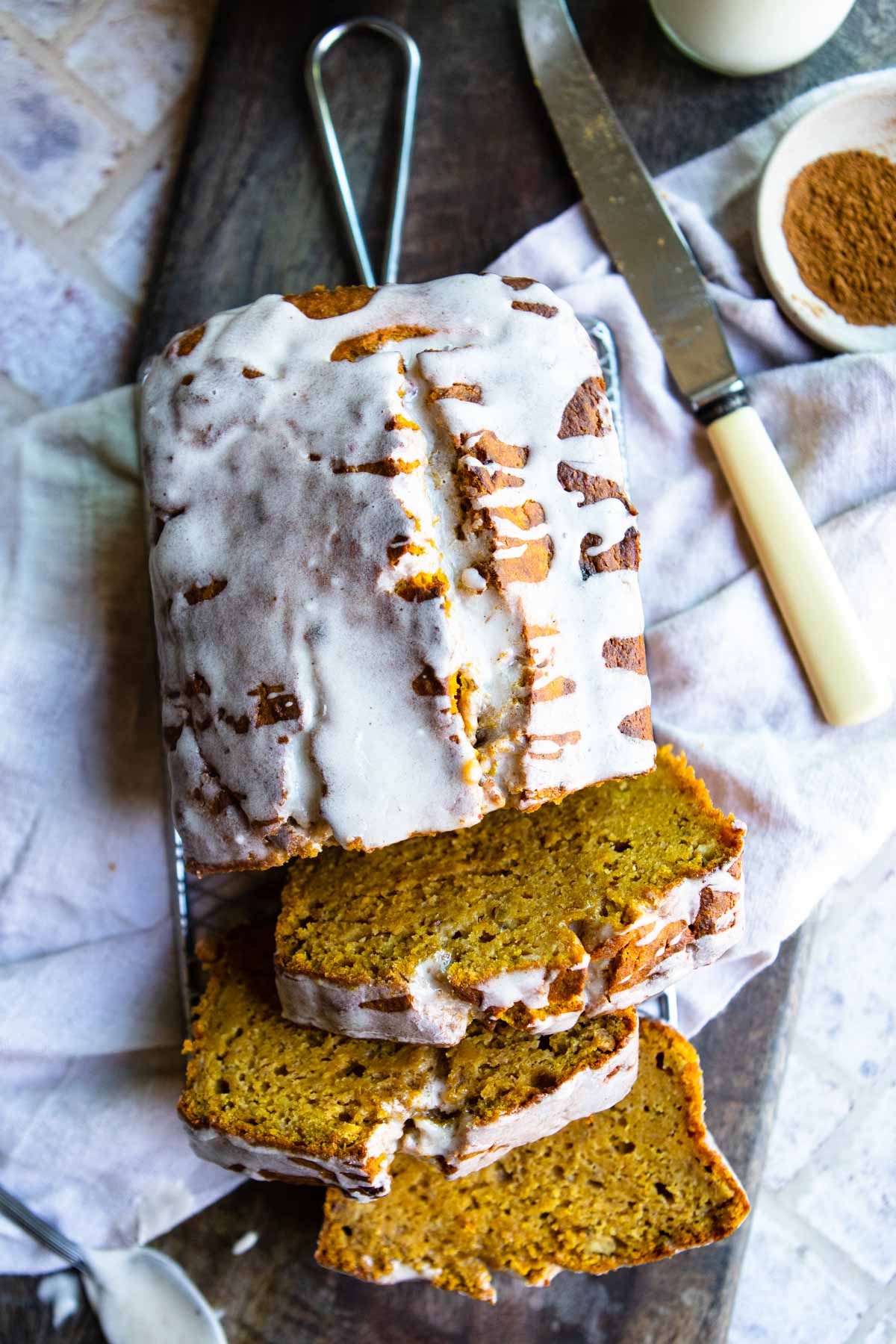 pumpkin glaze for pumpkin bread poured all over a loaf of pumpkin banana bread 