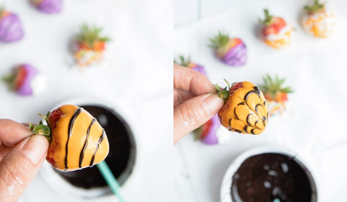 dark chocolate squiggly lines piped onto a orange colored chocolate dipped strawberry 