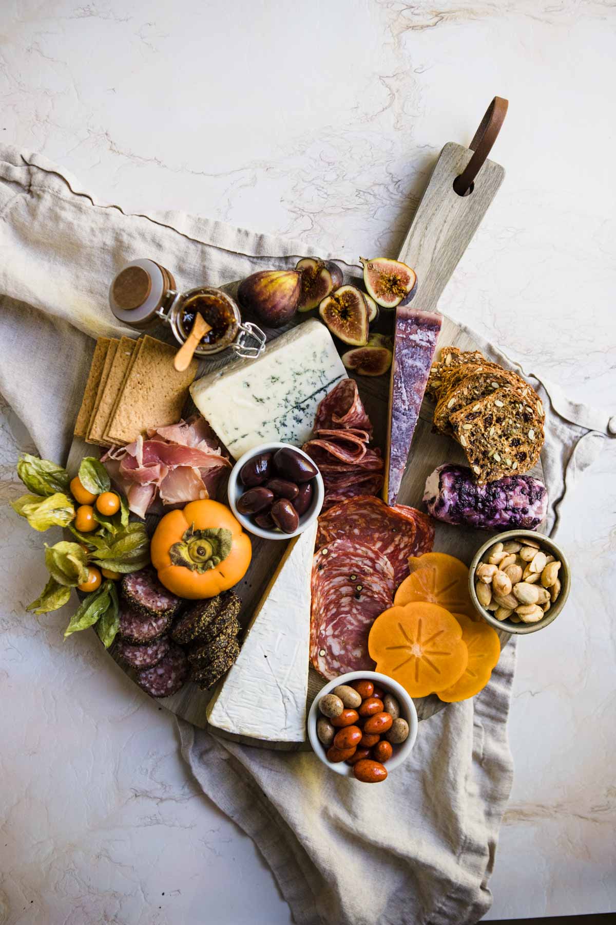 nuts, olives and sweet chocolate covered almonds are added to a seasonal Fall charcuterie board