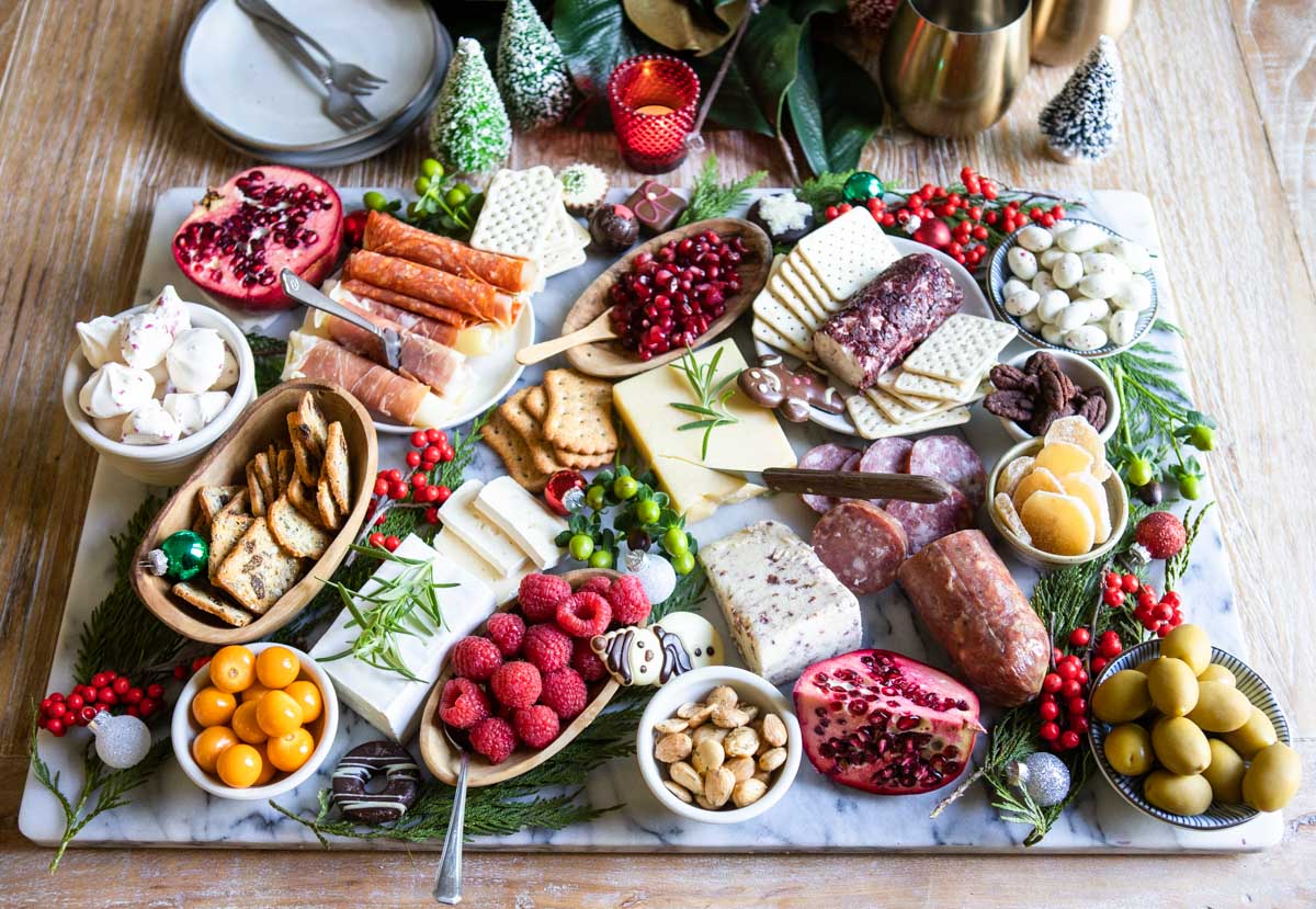 holiday meat and cheese grazing board made on a marble board set on a wood dining table