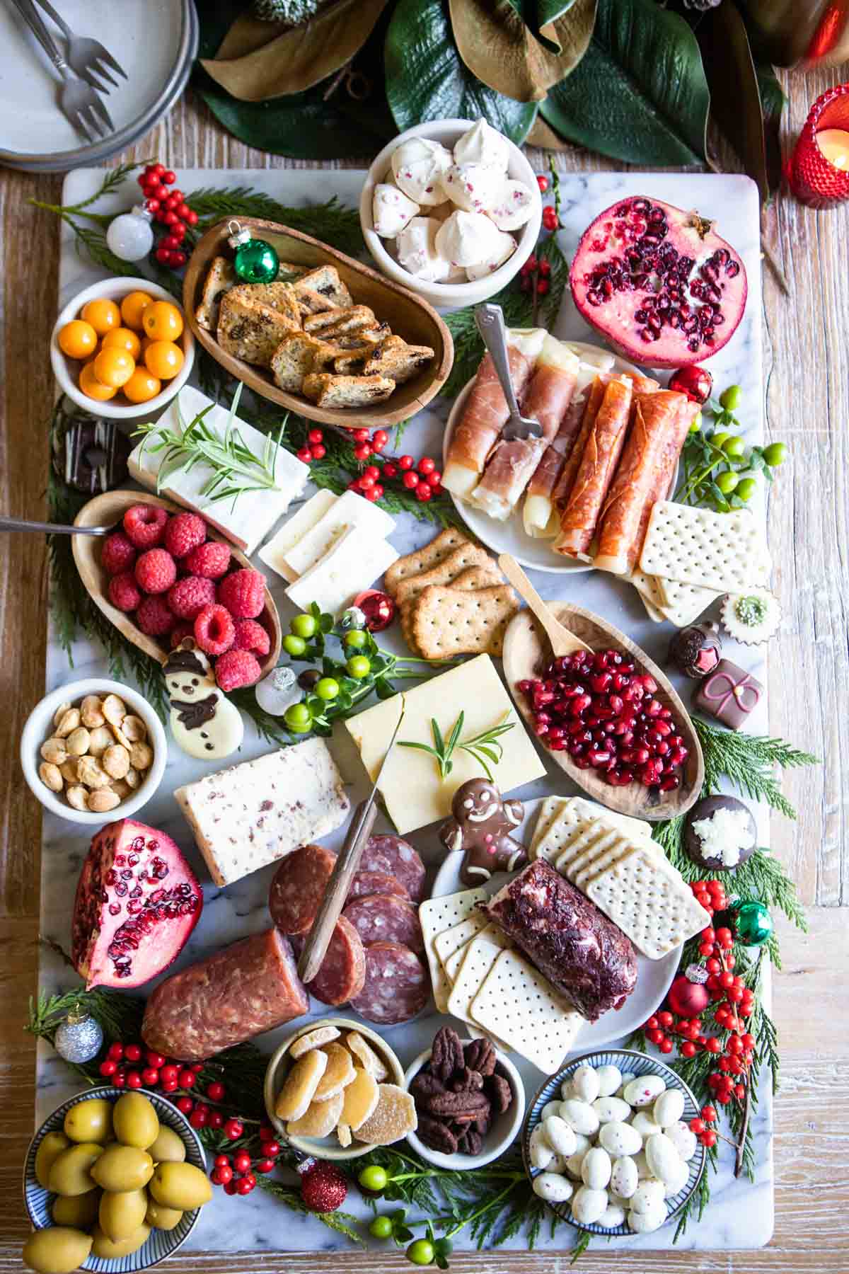 meat and cheese board with festive red and green decorations for a holiday party
