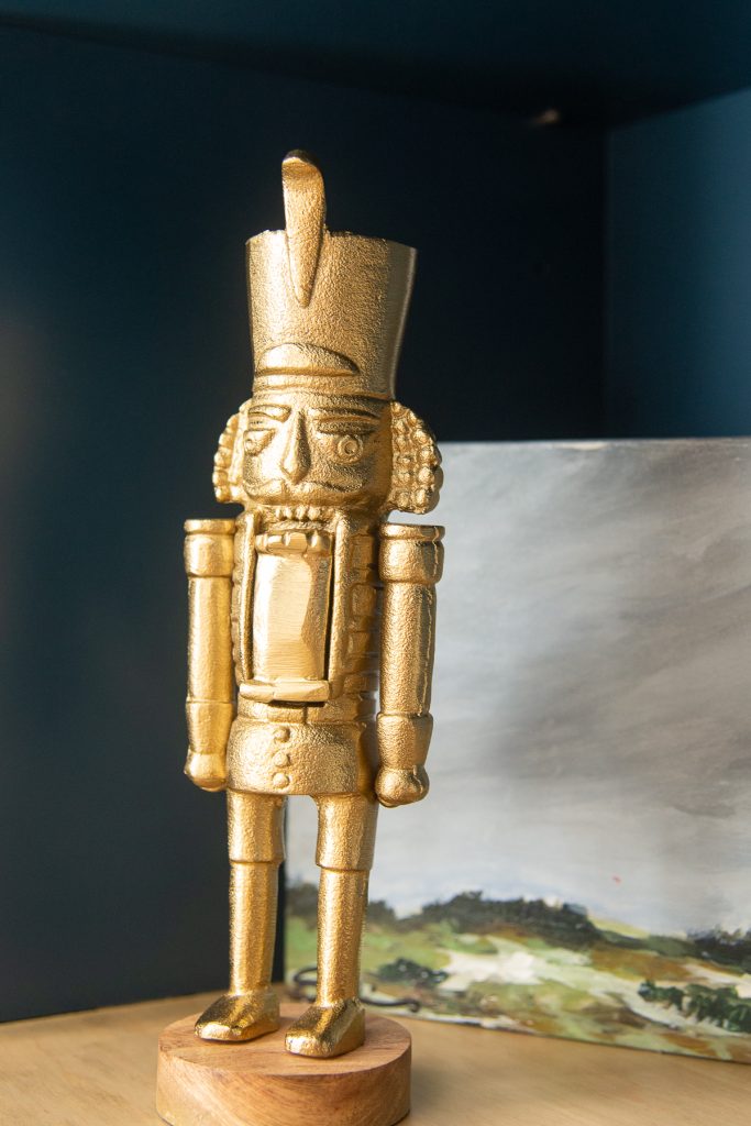 gold nutcracker on a bookshelf