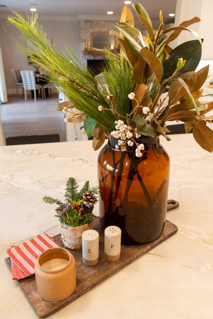 amber glass vase filled with holiday greens