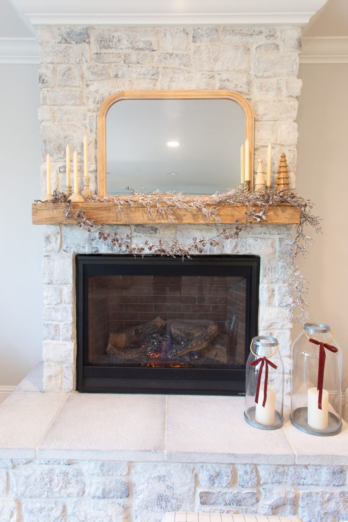 reclaimed wood mantel on a stone fireplace decorated for Christmas