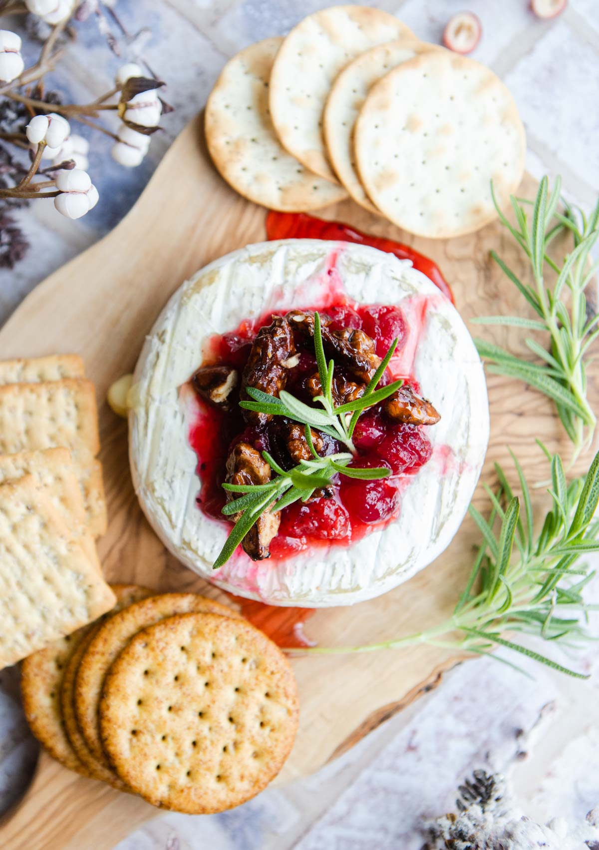 baked cheese topped with jam and fresh rosemary sprigs