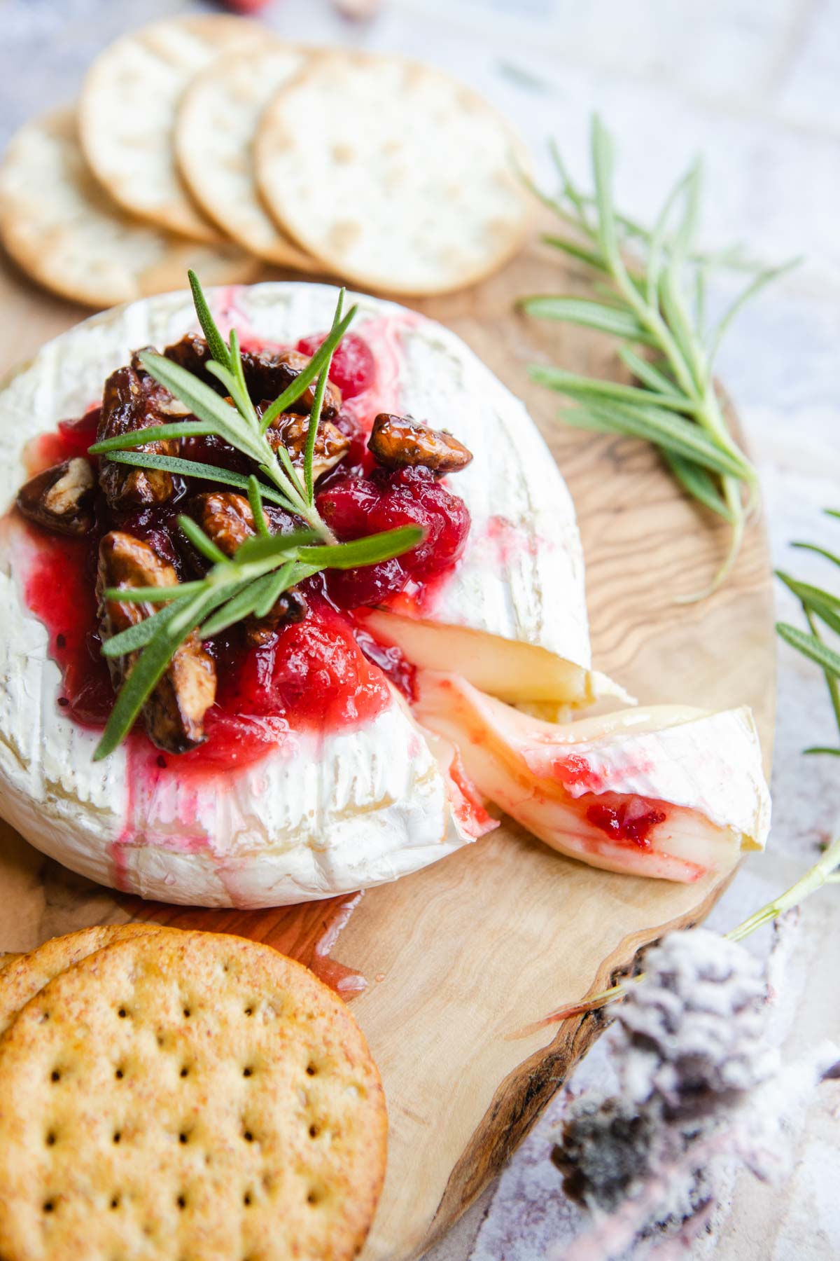 rosemary and cranberry sauce on a wheel of cheese
