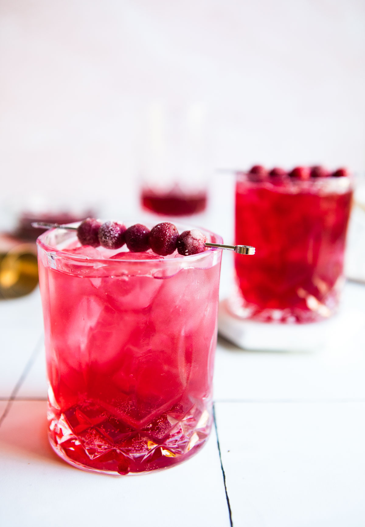 ginger cranberry gin cocktails in clear glasses with cranberry garnish
