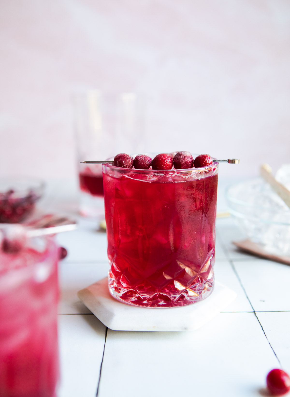 cranberry gin cocktail garnished with cranberries in a cut crystal glass