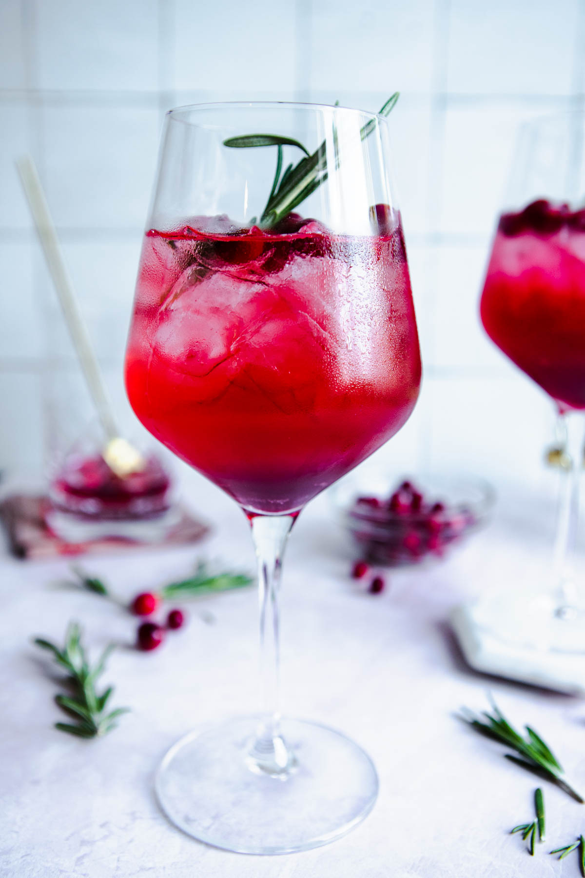 cranberry christmas cocktail garnished with cranberries and rosemary