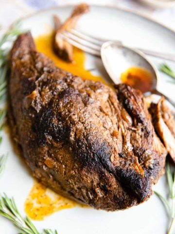 slow cooked tri tip on a platter drizzled with cooking juices